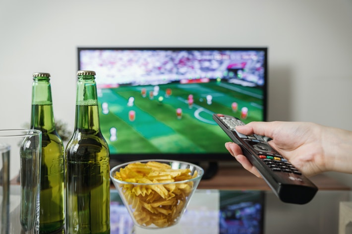 Person watching a football match on TV